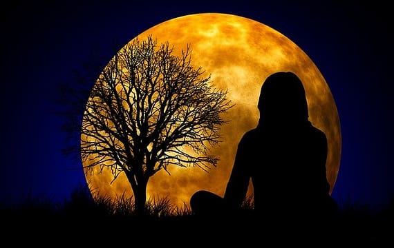 stille Meditation - eine Frau meditiert im Mondschein